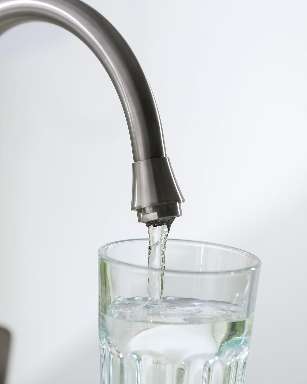 Water running from a kitchen tap into a glass
